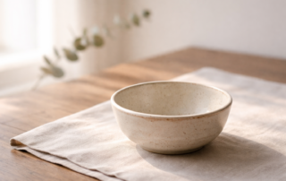 Cuenco de cerámica con luz natural, símbolo de sostén y bienestar sostenible
